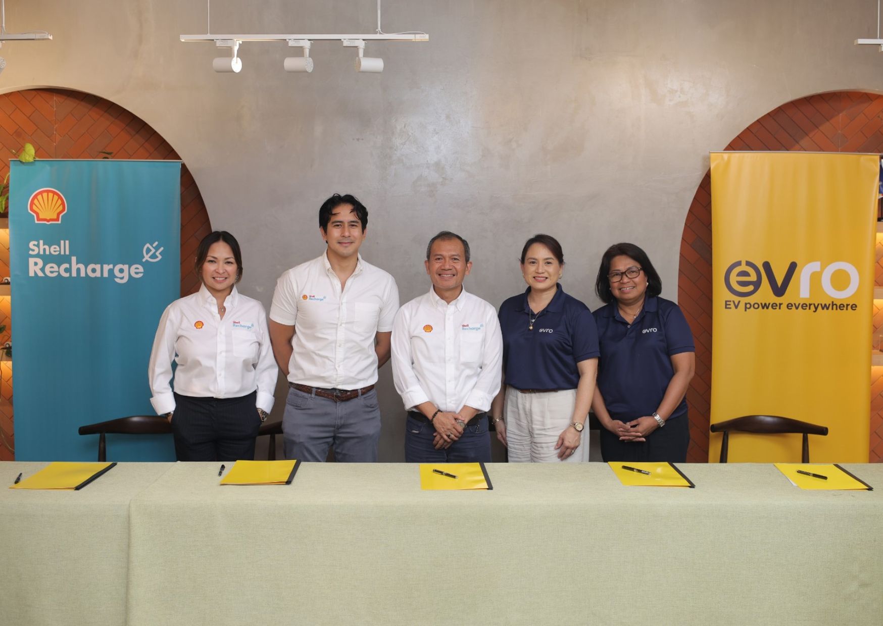 A Group photo of Evro and Shell Philippines executives in front of their respective banners