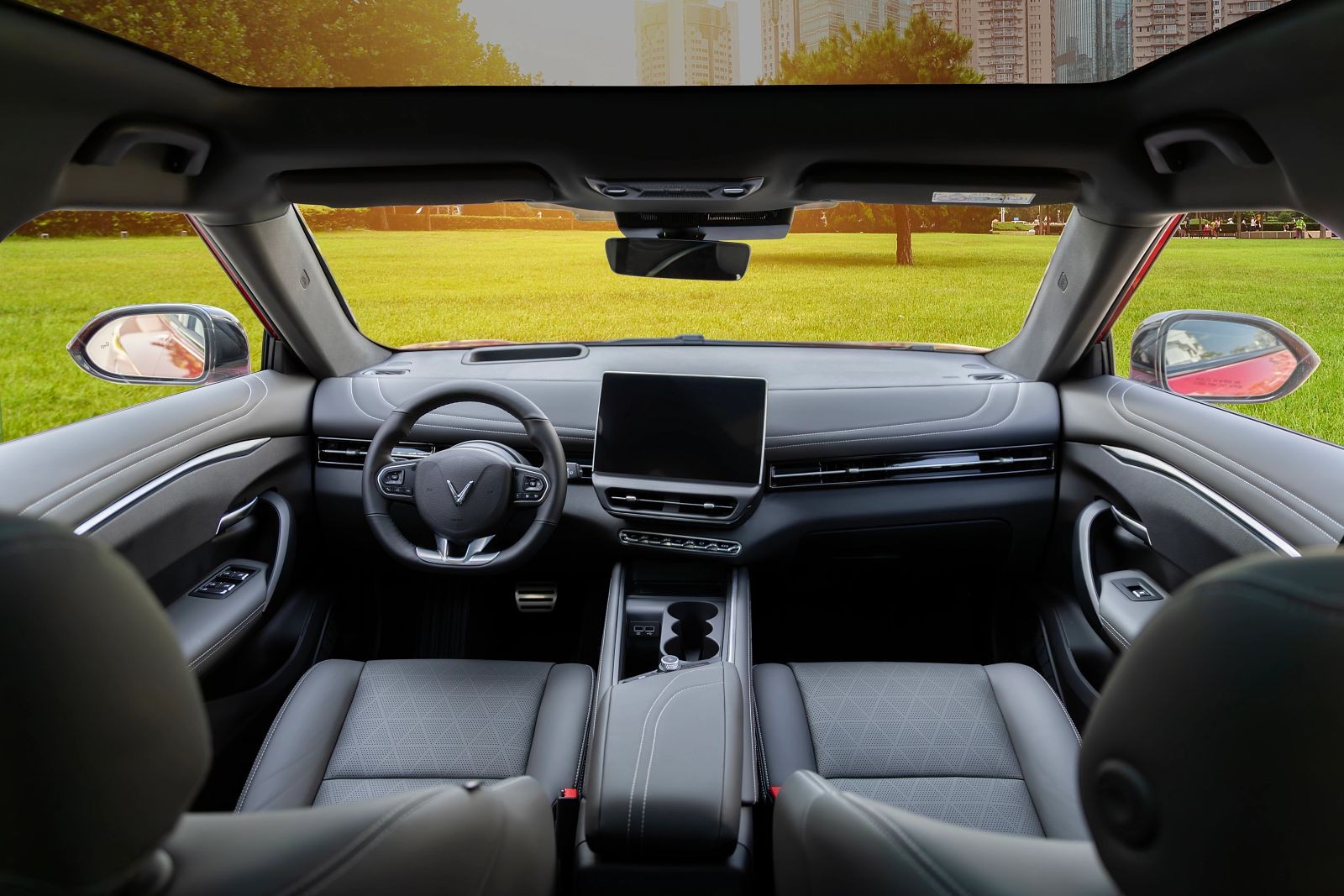 VinFast VF 7 front occupant interior. The instrument panel along with the infotainment system is angled toward the driver