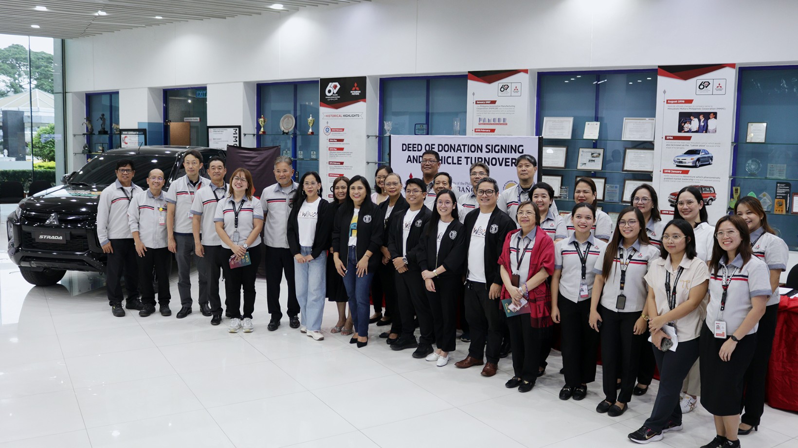 MMPC Chairman Noriaki Hirakata (6th from left) and President and CEO Ritsu Imaeda (4th from left) turns over a Strada Athlete unit to UPLB led by Student Affairs Vice Chancellor Janette Malata-Silva (7th from left) in support of the Dunong Program.